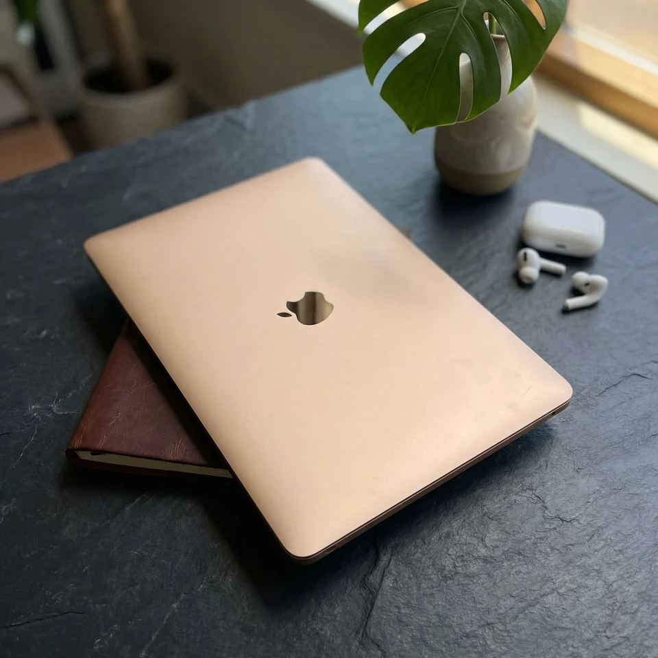 Refurbished MacBook Air in Rose Gold being used on a desk next to a coffee cup, illustrating portability and style