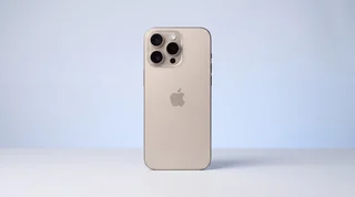 A single iPhone lying flat on a clean studio surface beside two contrasting USB-C cables, one neat and premium, one visibly cheap and frayed
