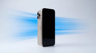 A pristine iPhone standing upright with a soft blue motion streak behind it on a clean studio surface