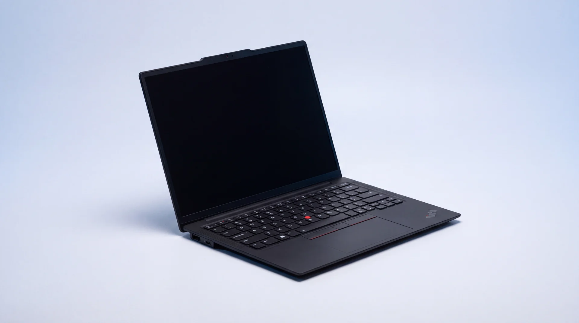 A single black Lenovo ThinkPad laptop open on a clean studio surface, showing its keyboard