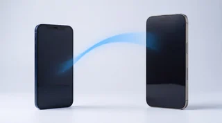 An older navy iPhone 12 and a newer titanium iPhone 16 Pro Max standing upright with a soft blue arc of light flowing between them, transferring data